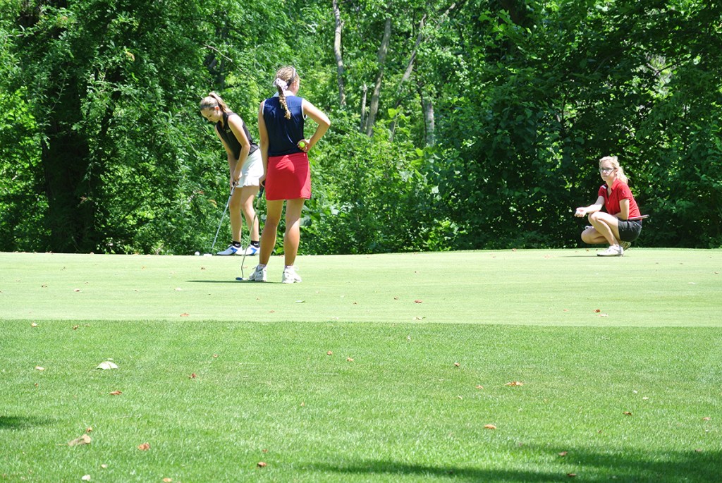 group of junior golfers putting